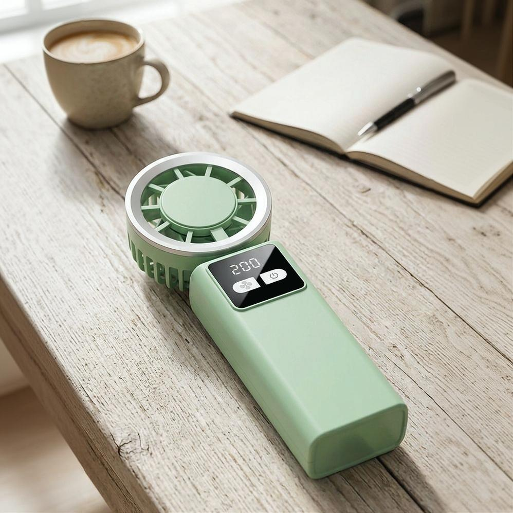 TurboBreeze handheld ice cooling fan on a desk with coffee and notebook